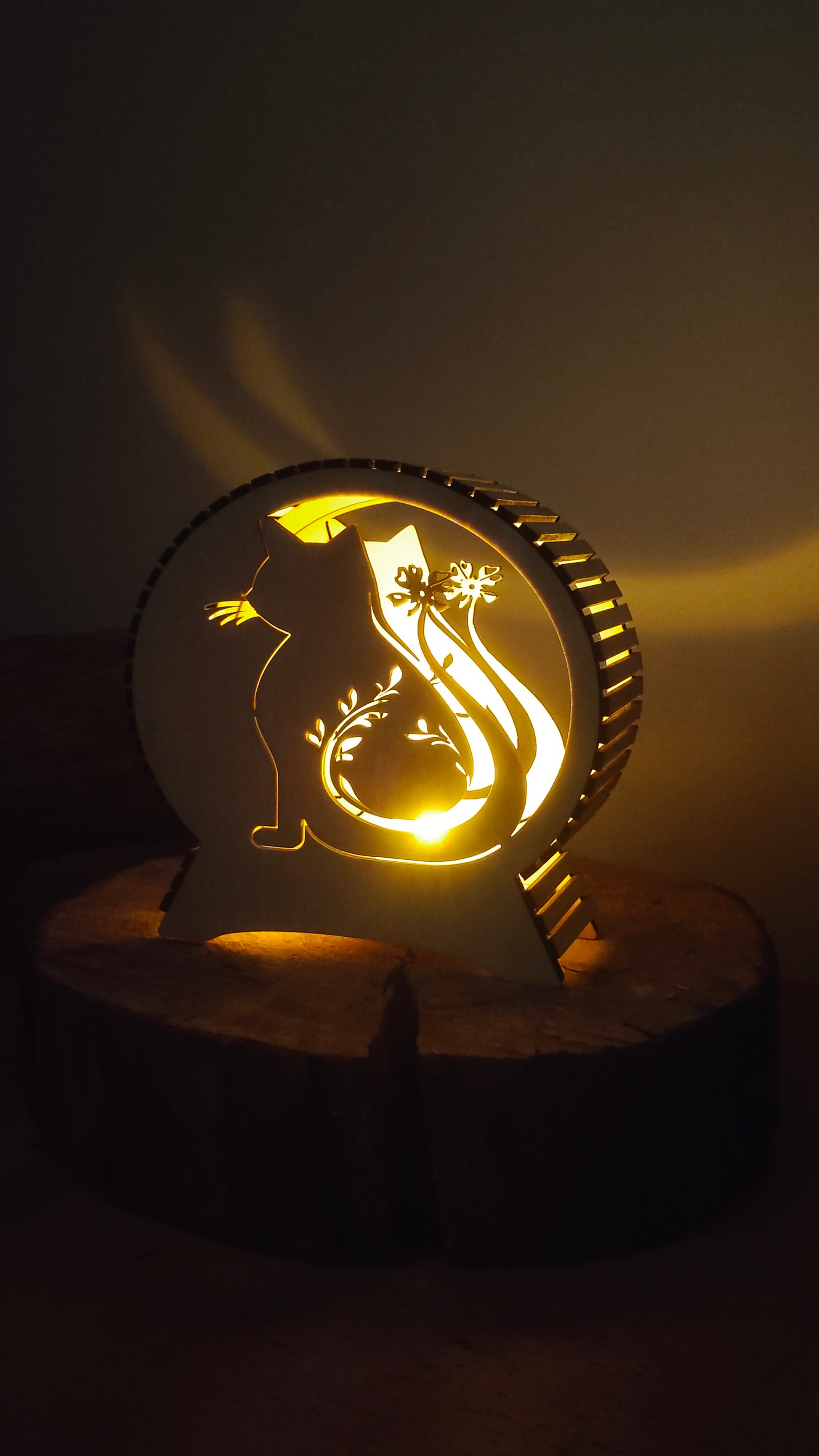 Petit format de lampe chat en bois allumé sur un rondin