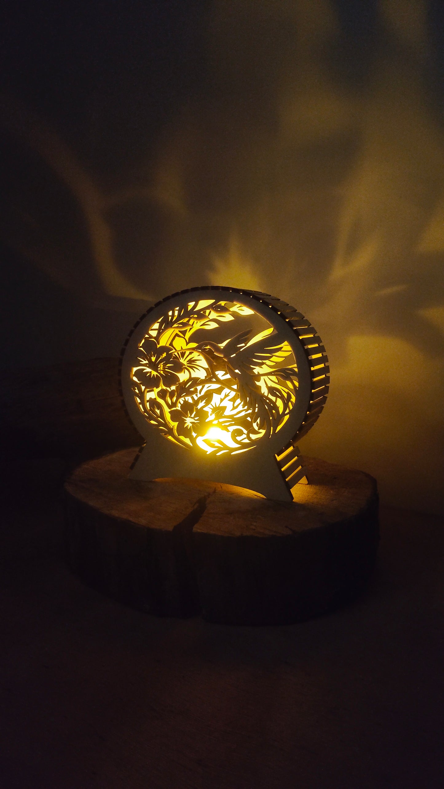 Petit format de lampe colibri en bois allumé sur un rondin
