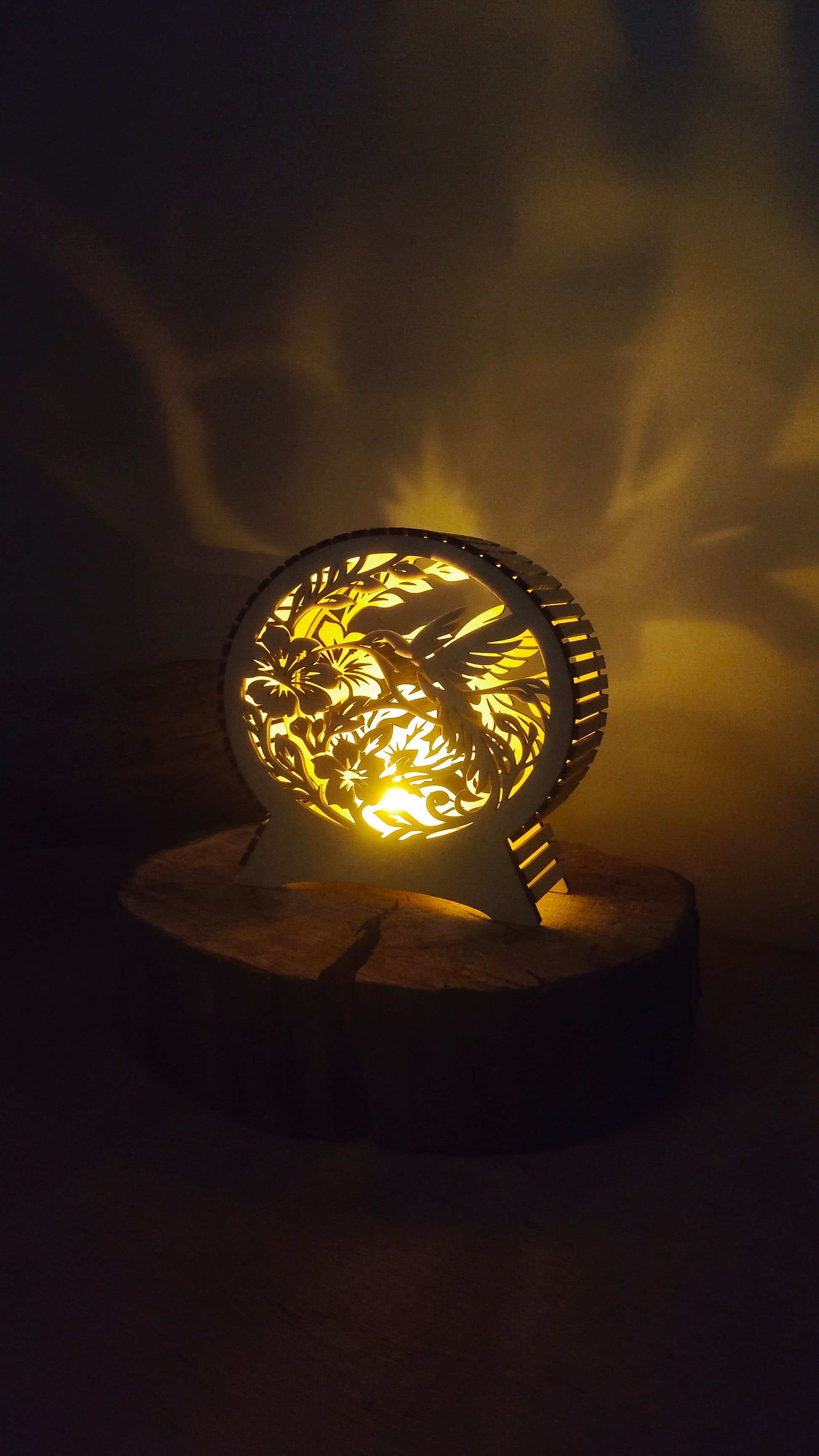 Petit format de lampe colibri en bois allumé sur un rondin